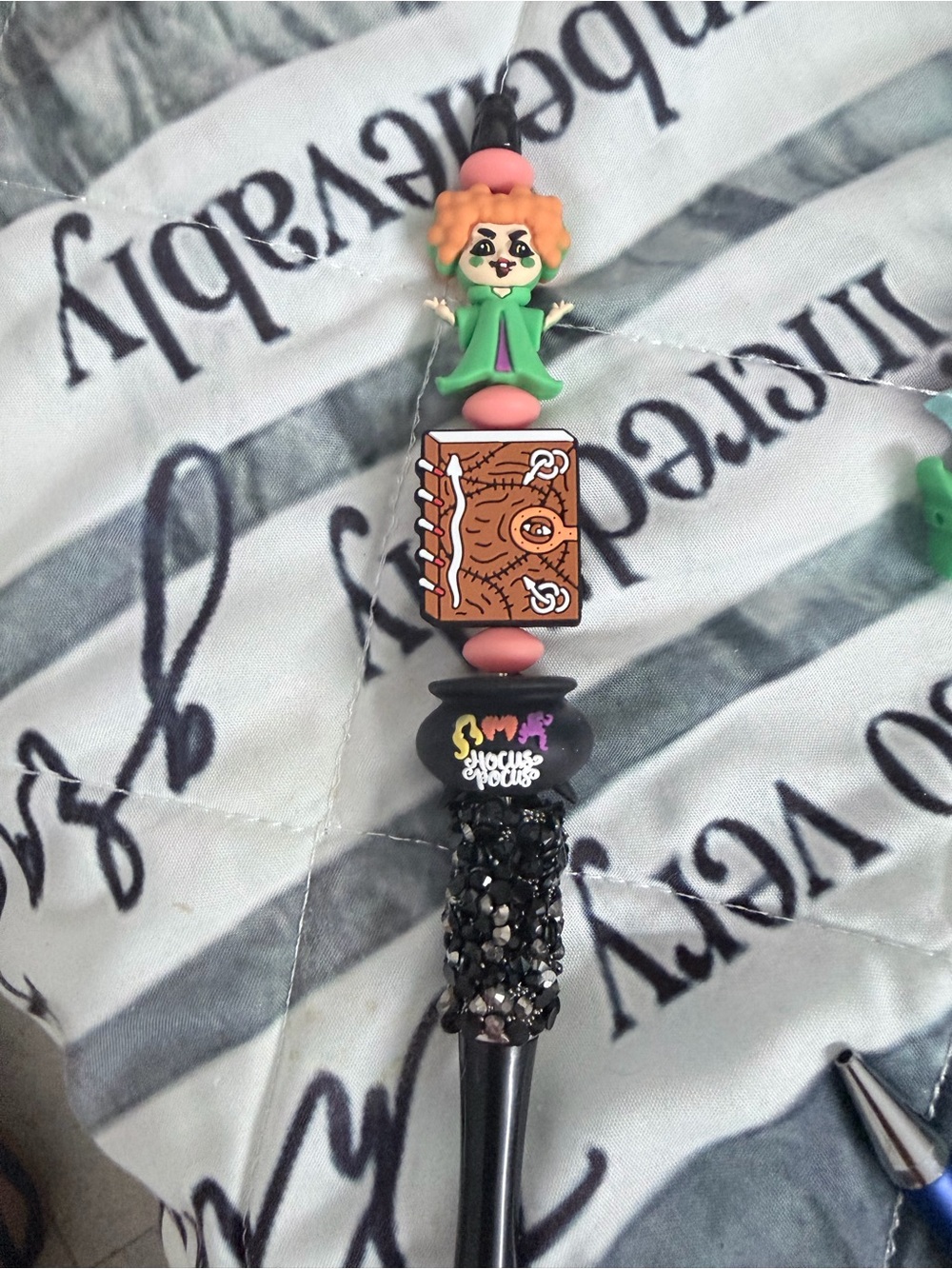 Hocus Pocus beaded pen with red haired witch, book, and cauldron.